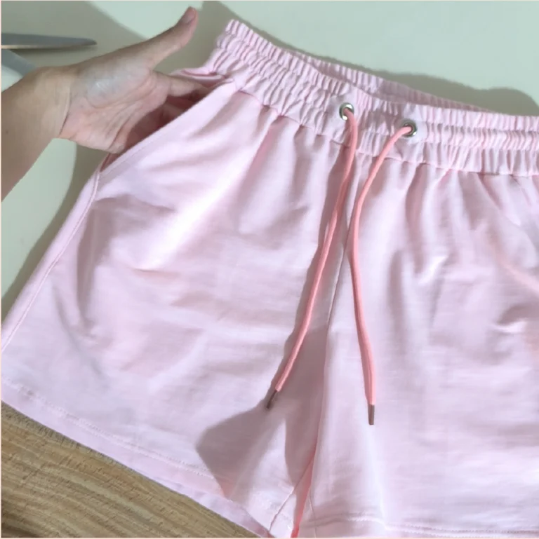 Detalle de bolsillo y pretina elástica en el patrón de costura Short Rose Niña confeccionado en tela rosada.