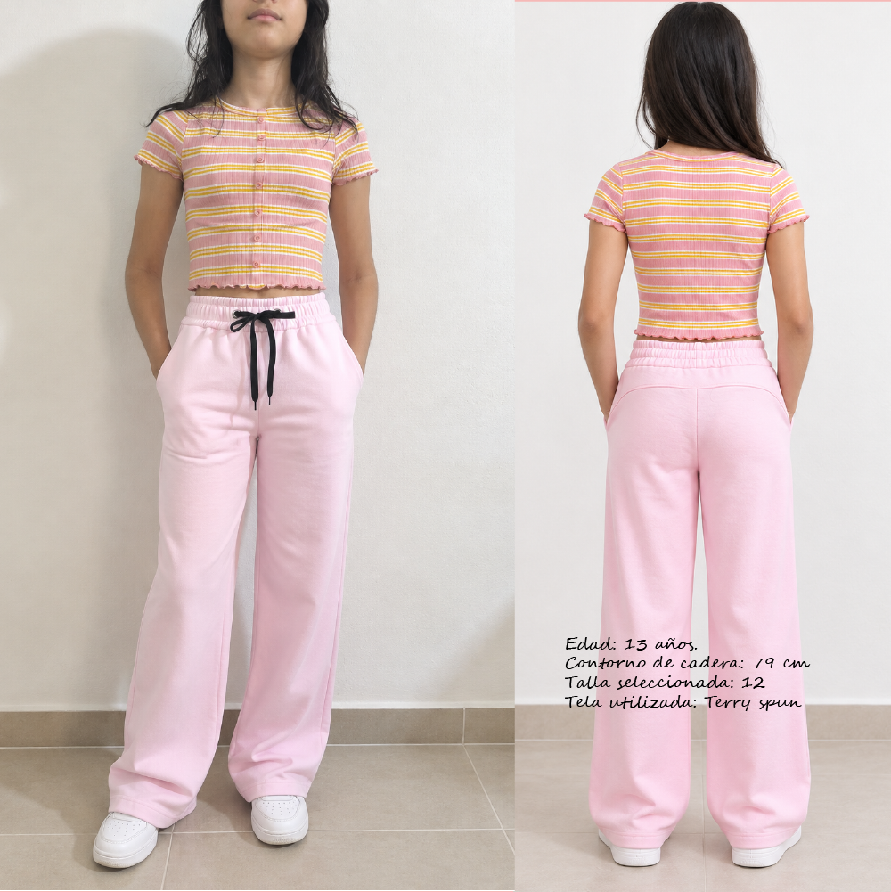 Niña vistiendo patrón de costura Pantalón Rose Niña, modelo deportivo wide leg rosa con elástico y bolsillos laterales.