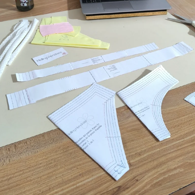 Piezas impresas del Patrón de costura Panty Li y telas cortadas sobre una mesa para un proyecto de lencería DIY.